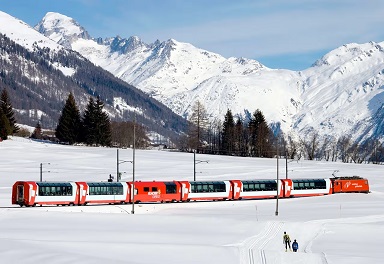 Glacier express Un train rouge traverse un paysage montagneux enneigé sous un ciel bleu.
