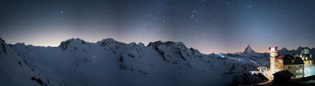 Gornergrat Paysage alpin nocturne avec montagnes enneigées et ciel étoilé.